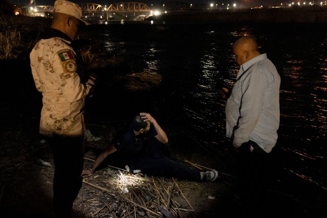 A man from Mexico sits on the bank of the Rio Grande River after being resuscitated by another man who jumped into the water and dragged him to shore, in Piedras Negras, Coahuila, Mexico, on February 24, 2024. Moments earlier, the man had led a group of migrants into the Rio Grande River with intentions to cross into Eagle Pass, Texas, U.S. This was the second of two failed crossing attempts made by this group who nearly drowned in the rushing current. (Photo by Cheney Orr/Reuters)