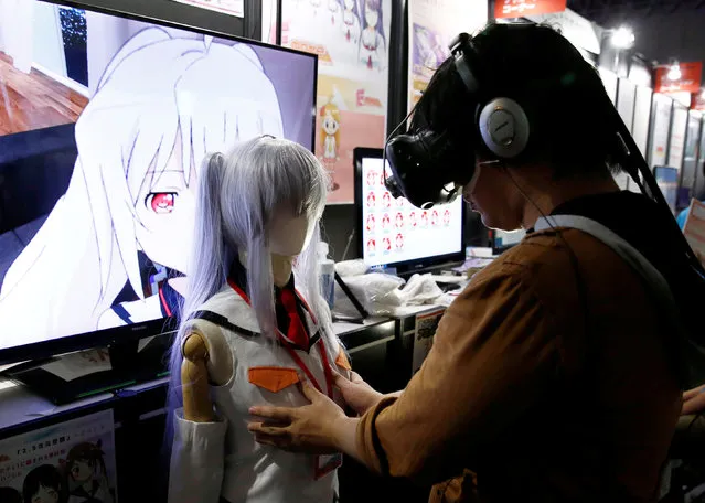 A man touches a mannequin as he tries out a M2 Co.Ltd's “E-mote” system as the monitor shows the image from the VR device at Tokyo Game Show 2016 in Chiba, east of Tokyo, Japan, September 15, 2016. (Photo by Kim Kyung-Hoon/Reuters)