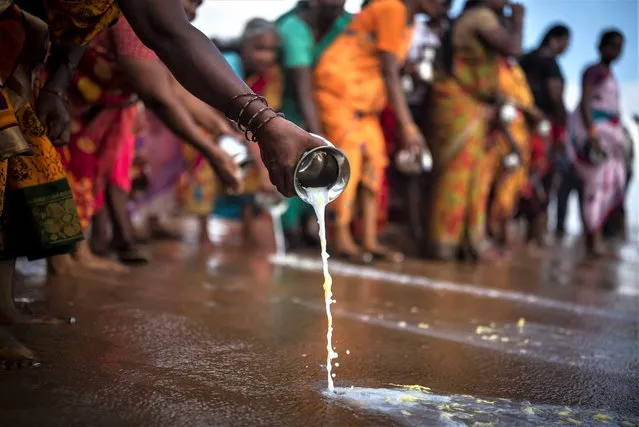 People pour milk in the waters of the Bay of Bengal as they pay homage to the victims during a prayer ceremony to mark the 18th anniversary of the 2004 Indian Ocean tsunami disaster, at Nochikuppam beach, in Chennai, India, 26 December 2022.  On 26 December 2022 countries bordering the Indian Ocean mark the 18th anniversary of the 2004 tsunami which was triggered by a 9.2 earthquake off the west coast of northern Sumatra, and killed an estimated 230,000 people in 14 countries. (Photo by Idrees Mohammed/EPA/EFE)