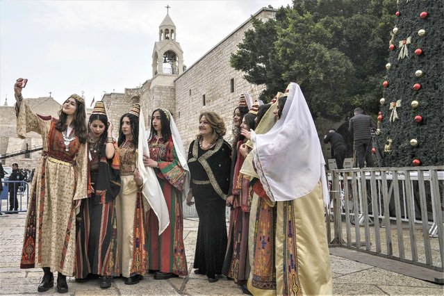 Women pose for a photo as they visit the Church of the Nativity, traditionally believed to be the birthplace of Jesus Christ, in the West Bank town of Bethlehem, Saturday, December 24, 2022. (Photo by Mahmoud Illean/AP Photo)
