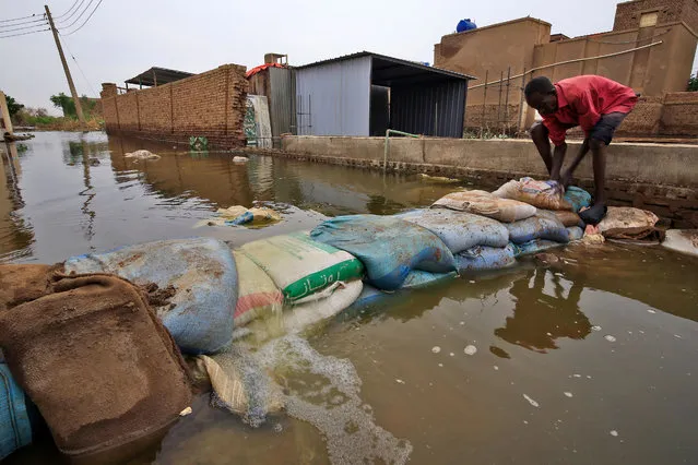 A Sudanese man build a barricade amidst flood waters in Tuti island, where the Blue and White Nile merge between the twin cities of the capital Khartoum and Omdurman, on September 3, 2020. On Tuti Island, the highest Nile waters since records began a century ago have left people struggling to build dams by filling bags with sand and small stones to stem the flood. Officials say that across Sudan seasonal floods have killed 94 people, injured 46 and destroyed or damaged over 60,000 homes, with the river level rising to 17.43 metres (57 feet feet). (Photo by Ashraf Shazly/AFP Photo)