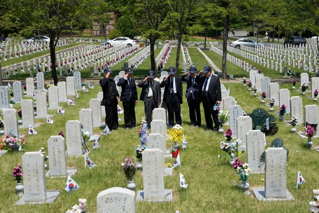 South Korean Vietnam War veterans salute to the gravestone of their comrade Kim Byung-Chul who died during the Vietnam War, on the eve of Memorial Day at the National Cemetery in Seoul, South Korea, Thursday, June 5, 2025. (Photo by Ahn Young-joon/AP Photo)