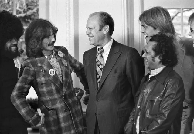 President Gerald Ford smiles as he talks with George Harrison, second from left, at the White House in Washington, December 13, 1974.  Jack Ford, 22, the president's son, second from right, invited Harrison to the White House for lunch.  With them are keyboardist Billy Preston, far left, and sitar player Ravi Shankar, right.  (Photo by Charles Bennett/AP Photo)