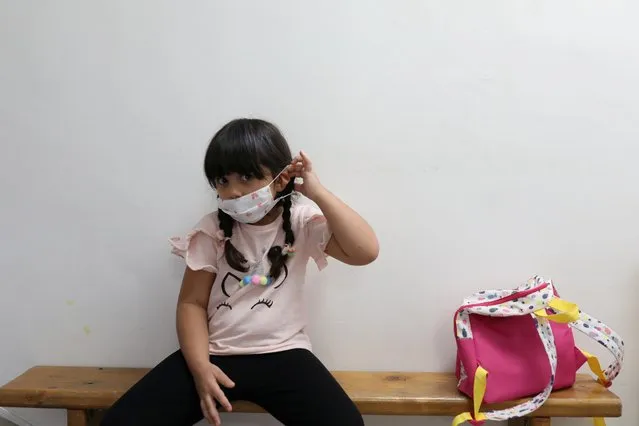A girl takes off the protective face mask as she looks on at a kindergarten in Tehran, Iran on September 27, 2020. (Photo by Majid Asgaripour/WANA via Reuters)