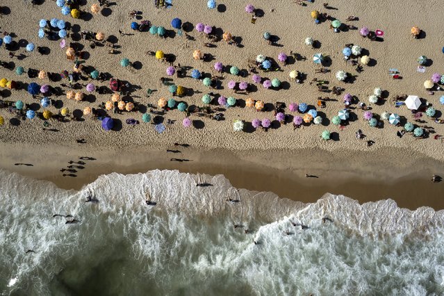 Umbrellas dot the shore of Leblon beach in Rio de Janeiro, Brazil, Friday, January 27, 2023. The Brazilian summer can reach outstanding temperatures on the first months of the year. The thermal sensation reached 50 degrees Celsius on a weekend and the weather forecast keeps predicting blue sky and heat for the following weeks. (Photo by Bruna Prado/AP Photo)
