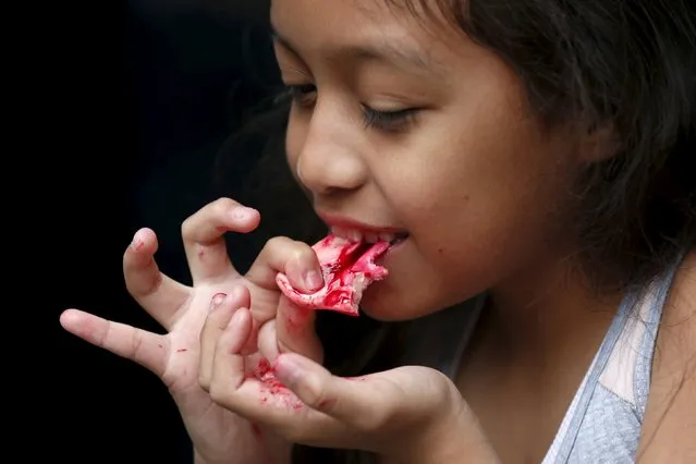 Alejandra Rodriguez, 8, eats a bloody nose made of gummy candy and red jelly at the Zombie Gourmet homemade candy manufacturer on the out skirts of Mexico City October 30, 2015. (Photo by Carlos Jasso/Reuters)