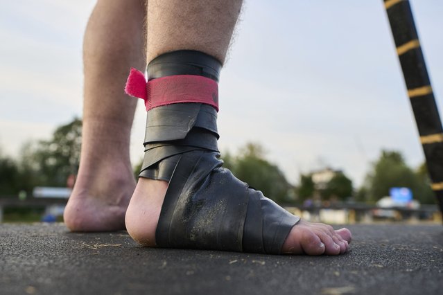 An athlete, wearing a rubber band on his foot to climb, prepares to run towards a long pole to jump across a body of water during a Fierljeppen competition in Kockengen, Netherlands, Wednesday, August 27, 2025. (Photo by Peter Dejong/AP Photo)