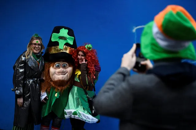 A man takes a picture of people dressed as leprechauns on St. Patrick's Day in Dublin, Ireland on March 17, 2018. (Photo by Clodagh Kilcoyne/Reuters)