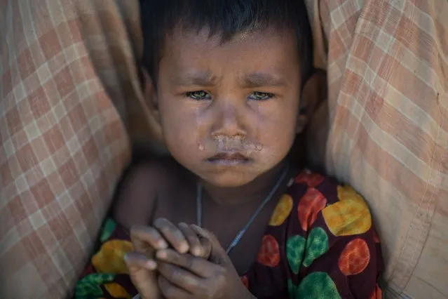 A Rohingya Muslim refugee child cries as she sits in the Kutupalong refugee camp in Cox's Bazar on December 4, 2017. Rohingya are still fleeing into Bangladesh even after an agreement was signed with Myanmar to repatriate hundreds of thousands of the Muslim minority displaced along the border, officials said on November 27. (Photo by Ed Jones/AFP Photo)