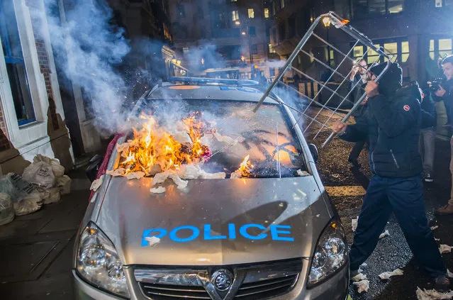 A police car is set on fire during the Million Mask march in central London, UK on November 5, 2015. (Photo by  Guy Bell/Rex Shutterstock)