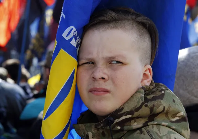 A young ultra-right activist holds a flag as he attends a rally against tycoons in national politics and economy in central Kiev, Ukraine, Tuesday, April 3, 2018. (Photo by Efrem Lukatsky/AP Photo)