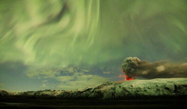 The Northern Lights are seen above the ash plume of a volcano in Eyjafjallajokull, Iceland, April 22, 2010. (Photo by Lucas Jackson/Reuters)