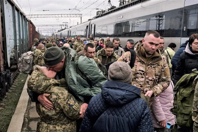 A Ukrainian woman soldier, left, kisses her husband as they meet at a railway station close to the frontline in Kramatorsk, Donetsk region, Ukraine, Wednesday, March 29, 2023. (Photo by Libkos/AP Photo)