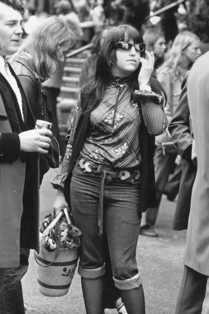 A woman standing next to a teddy-boy sells leather belts at the Rock n' Roll Festival, Wembley Stadium, 1972. (Photo by Evening Standard/Getty Images)