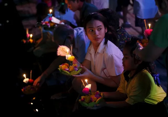 People pray before casting a krathong into a canal during the Loy Krathong festival in Nonthaburi province, on the outskirts of Bangkok, November 25, 2015. Believers float krathongs during the festival, which is held as a symbolic apology to the goddess of the river. (Photo by Chaiwat Subprasom/Reuters)