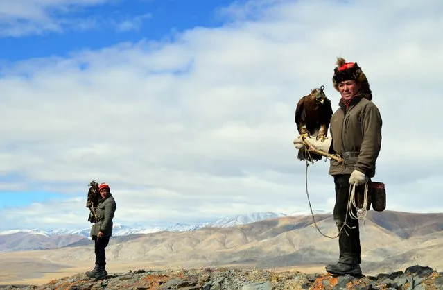 Eagle hunters Ushkish, at right, and Berik prepared to hunt atop a mountain. (Photo by Brad Ruoho/The Star Tribune)