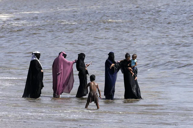 A group of Muslim women cool off in the Arabian Sea coast on a hot afternoon in Mumbai, India, Monday, May 22, 2023. Swathes of India from the northwest to the southeast braced for more scorching heat Monday, as extreme temperatures strike parts of the country. (Photo by Rajanish Kakade/AP Photo)