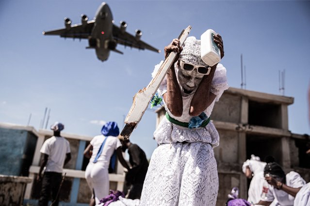 A woman reacts as she attends Fet Gede, the traditional Haitian Day of the Dead celebration at the Port-au-Prince cemetery, in Haiti, on November 1, 2025. Fet Gede is the annual celebration when practitioners of vodou parade and believe to be possessed by the spirits of the dead. (Photo by Clarens Siffroy/AFP Photo)
