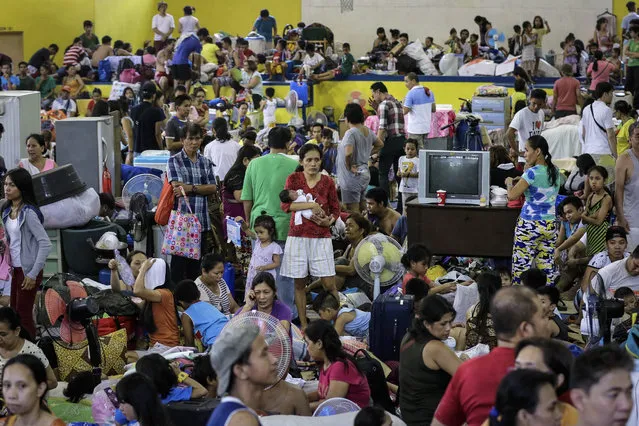 Filipinos are temporarily sheltered at a basketball gymnasium after a fire in Mandaluyong City, east of Manila, Philippines, 14 November 2016. According to reports, three died and more than 6,000 people were displaced after a fire, that reached the highest alarm and lasted for seven hours, broke out last night in Mandaluyong City. (Photo by Mark R. Cristino/EPA)