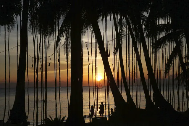 Tourists watch the sunset a day before the government implements the temporary closure of the country's most famous beach resort island of Boracay, in central Aklan province, Philippines, on Wednesday, April 25, 2018. Tourists are spending their final hours on Boracay, enjoying the Philippine island's famed white-sand beaches before it closes for up to six months to recover from overcrowding and development. (Photo by Aaron Favila/AP Photo)
