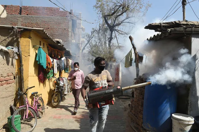 A health worker operates a fogging machine along as a precautionary measure against the bird flu in Sola area, on the outskirts of Ahmedabad on March 5, 2021. (Photo by Sam Panthaky/AFP Photo)