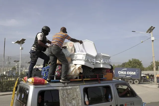 A policeman checks a public transport driver's cargo that includes coffins, in Port-au-Prince, Haiti, Saturday, July 1, 2023. (Photo by Joseph Odelyn/AP Photo)