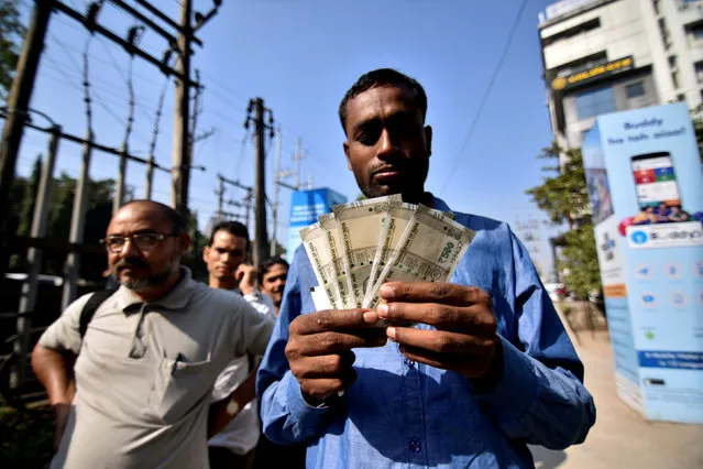 A man shows the new 500 Indian rupee banknotes after withdrawing them from an ATM in Guwahati, India, November 25, 2016. (Photo by Anuwar Hazarika/Reuters)