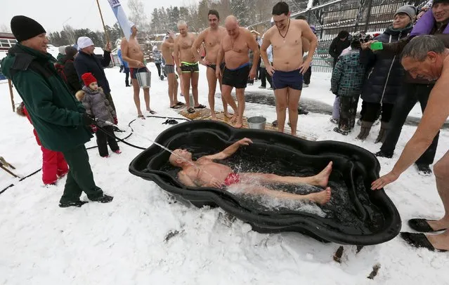 Mikhail Sashko, chairman and one of the founders of the Cryophile winter swimmers club, bathes in cold water during a flash mob, part of a celebration of Polar Bear Day at the Royev Ruchey Zoo in a suburb of the Siberian city of Krasnoyarsk, Russia, November 29, 2015. (Photo by Ilya Naymushin/Reuters)