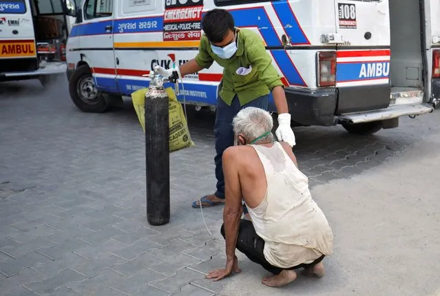 A patient with a breathing problem is helped by his relative to enter a COVID-19 hospital for treatment, amidst the spread of the coronavirus disease (COVID-19), in Ahmedabad, India, April 19, 2021. (Photo by Amit Dave/Reuters)