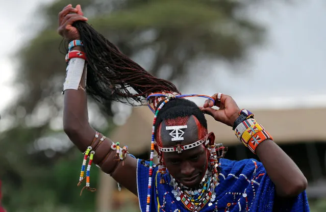 A Maasai moran athlete works on his hair as he prepares for the 2016 Maasai Olympics at the Sidai Oleng Wildlife Sanctuary, at the base of Mt. Kilimanjaro, near the Kenya-Tanzania border in Kimana, Kajiado, Kenya December 10, 2016. (Photo by Thomas Mukoya/Reuters)