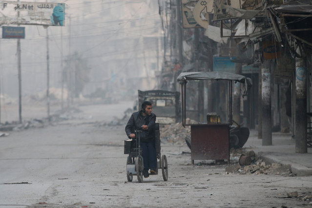 A man on a wheelchair flees into the remaining rebel-held areas of Aleppo, Syria December 9, 2016. (Photo by Abdalrhman Ismail/Reuters)