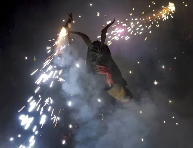 A reveller dressed as a devil holds a stick with fireworks during traditional “Correfocs” (fire runs) to mark the end of the local festivities in Palma, on the Spain's Balearic Island of Mallorca,  January 23, 2016. (Photo by Enrique Calvo/Reuters)