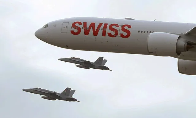 A new Boeing 777-300 passenger jet of Swiss airline is accompanied by two F/A-18C Hornet jets of the Swiss Air Force upon its arrival at Zurich airport, Switzerland January 29, 2016. (Photo by Arnd Wiegmann/Reuters)