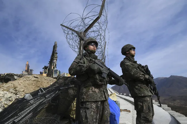 South Korean soldiers stand guard as construction equipments destroy a guard post in the Demilitarized Zone dividing the two Koreas in Cheorwon Thursday, November 15, 2018. Relations between the Koreas have improved this year, with the North entering disarmament talks with a vague promise to achieve complete denuclearization of the Korean Peninsula. (Photo by Jung Yeon-je/Pool Photo via AP Photo)