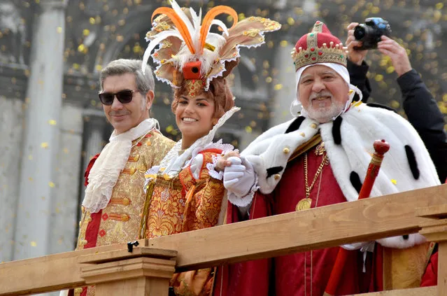 Irene Rizzi, center, poses with a man impersonating the Doge of Venice, right, after descending from the bell tower into St. Mark's Square, in Venice, Sunday, January 31, 2016. Carnival-goers in Venice are being asked by police to momentarily lift their masks as part of new anti-terrorism measures for the annual festivities. Sunday's main crowd-pleaser known as the Flight of the Angel went off without a hitch. In that event, a costumed young woman, attached by wires, “flies” over the crowd, starting from St. Mark's bell tower and gradually descending to the square. (Photo by Luigi Costantini/AP Photo)