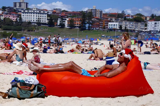 A tourist sits on an inflatable seat while wearing a Christmas hat and celebrating Christmas Day at Sydney's Bondi Beach in Australia, December 25, 2016. (Photo by David Gray/Reuters)