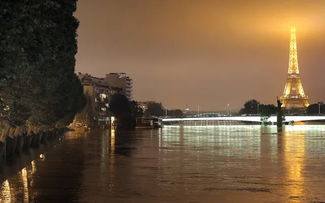 View of the flooded banks of the river Seine in front of the Eiffel tower in Paris, Friday, June 3, 2016. Both the Louvre and Orsay museums were closed as the Seine, which officials said was at its highest level in nearly 35 years, was expected to peak sometime later Friday. (Photo by Christophe Ena/AP Photo)