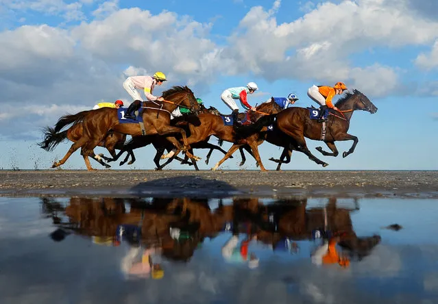 Jockeys and their horses reflect in the water of Laytown Beach during the third race of the day at the Laytown Races in Co Meath, Ireland on Tuesday,  September 12, 2023. (Photo by Clodagh Kilcoyne/Reuters)