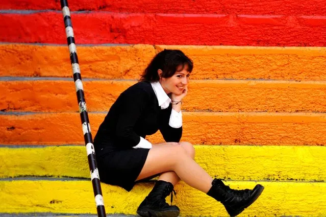 A woman poses on rainbow-colored stairs in Istanbul on November 19, 2013. (Photo by Ozan Kose/AFP Photo)