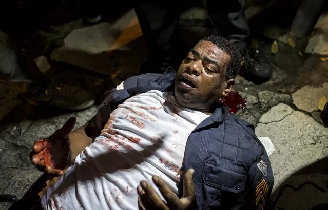 A policeman lies injured on the ground after clashing with demonstrators during a protest in Rio de Janeiro, on June 17, 2013. Officers in Rio fired tear gas and rubber bullets when a group of protesters invaded the state legislative assembly and threw rocks and flares at police. (Photo by Felipe Dana/Associated Press)