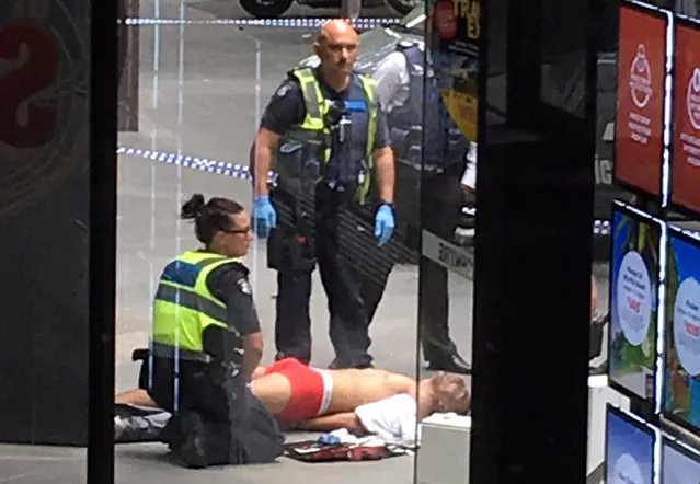 Police and medical staff surround a man as he lies on the footpath after a car hit pedestrians in central Melbourne, Australia, January 20, 2017. (Photo by Reuters/AAP)