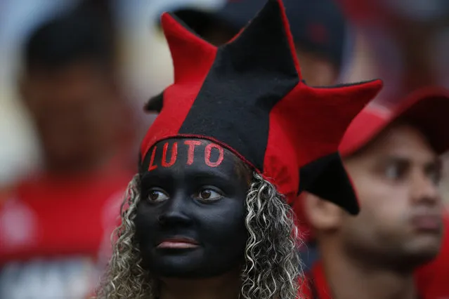 A woman, with the Portuguese word for “in mourning” painted on her forehead, waits for the start of a homage for the 10 teenage   players killed by a fire at the Flamengo training center last Friday, at the Maracana Stadium, in Rio de Janeiro, Brazil, Thursday, February 14, 2019, ahead of a soccer match between Flamengo and Fluminense. (Photo by Leo Correa/AP Photo)