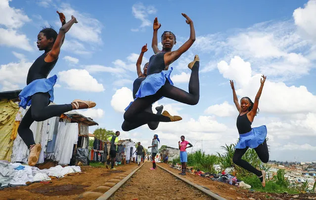 Young girls practice by the Kenya - Uganda railway line prior to the start of a Christmas ballet, in Kibera,  one of the busiest neighborhoods of Kenya's capital, Nairobi, Friday, December 15, 2023. The ballet project is run by Project Elimu, a community-driven nonprofit that offers after-school arts education and a safe space to children in Kibera. (Photo by Brian Inganga/AP Photo)