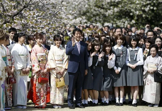 Japan's Prime Minister Shinzo Abe (C) poses with members of Japanese idol group Nogizaka46 and other kimono-clad show-business celebrities at a cherry blossom viewing party at Shinjuku Gyoen park in Tokyo April 18, 2015. (Photo by Issei Kato/Reuters)