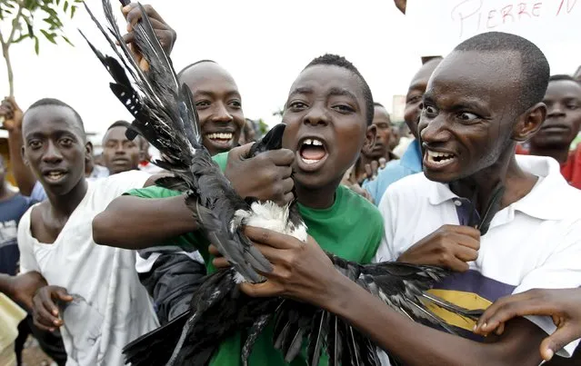 Protesters carry a dead crow as they chant anti-government slogans during demonstrations against the ruling CNDD-FDD party's decision to allow President Pierre Nkurunziza to run for a third five-year term in office, in Bujumbura, Burundi April 30, 2015. A senior U.S. diplomat told Burundi's President, Pierre Nkurunziza, on Thursday that the east African country risks boiling over if it stifles political opposition, as protests against the president entered a fifth day. (Photo by Thomas Mukoya/Reuters)