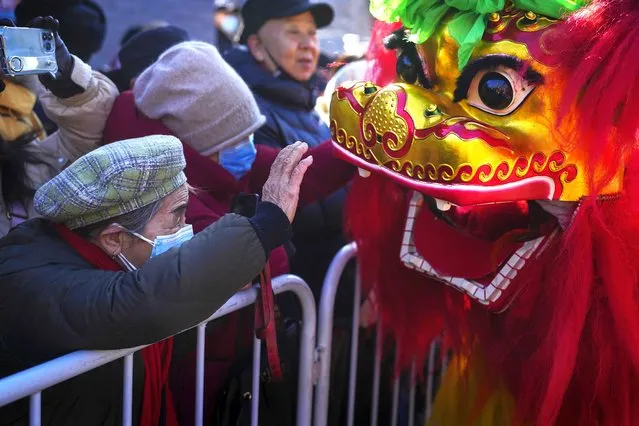 A woman touches the lion dance as residents watch traditional artists performance at the Dongyue Temple on the first day of the Chinese Lunar New Year in Beijing, Saturday, February 10, 2024. (Photo by Andy Wong/AP Photo)