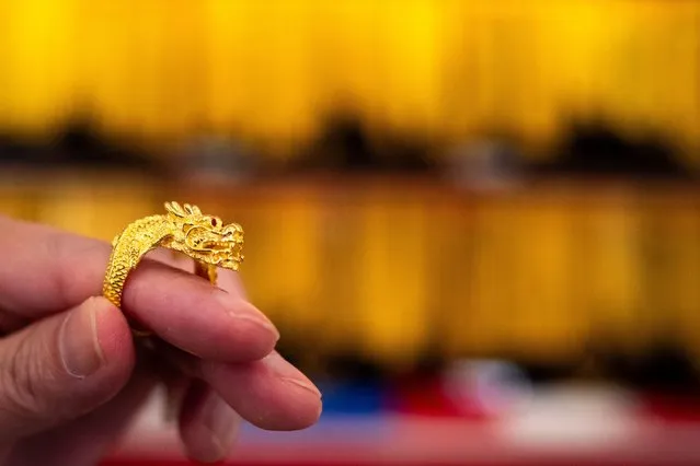 A gold seller holds a gold dragon ring at a gold shop ahead of Lunar New Year celebrations in Bangkok's Chinatown, Thailand, on February 8, 2024. (Photo by Athit Perawongmetha/Reuters)