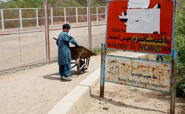 In this Monday, April 13, 2015 photo, an Afghan child laborer pushes a cart, at the Afghanistan-Iranian border point on the outskirts of Islam Qala in Herat province, west of Kabul, Afghanistan. (Photo by Massoud Hossaini/AP Photo)