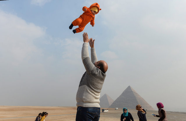 An Egyptian man tosses up his child in front of the pyramids of Giza, Egypt, 02 February 2017. Figures recently released by the Central Agency for Public Mobilization and Statistics (CAPMAS) showed that numbers of tourists visiting Egypt in November 2016 dropped by more than 10 percent compared to same month of 2015. (Photo by Mohamed Hossam/EPA)