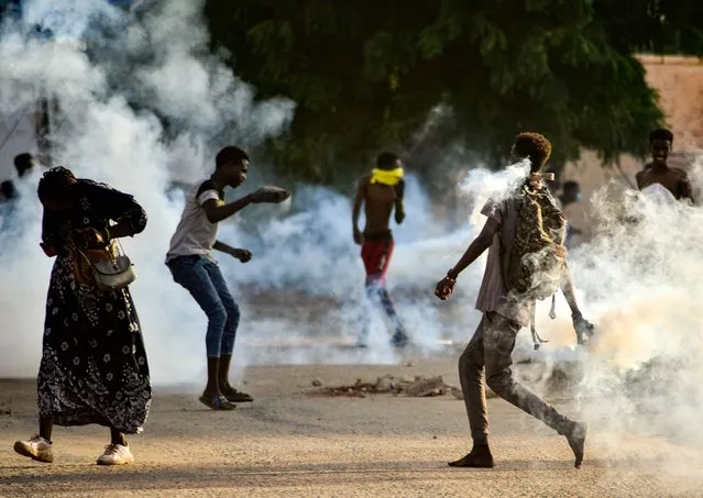 Sudanese youths confront security forces amidst tear gas fired by them to disperse protesters in the capital Khartoum, on October 27, 2021, amid ongoing demonstrations against a military takeover that has sparked widespread international condemnation. Security forces today made sweeping arrests of protesters who kept up demonstrations in the capital and other cities against this week's military coup, while the international community ramped up punitive measures. (Photo by AFP Photo/Stringer)